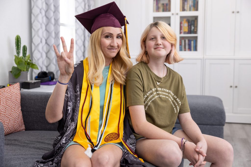 Parent in graduation cap sitting with child