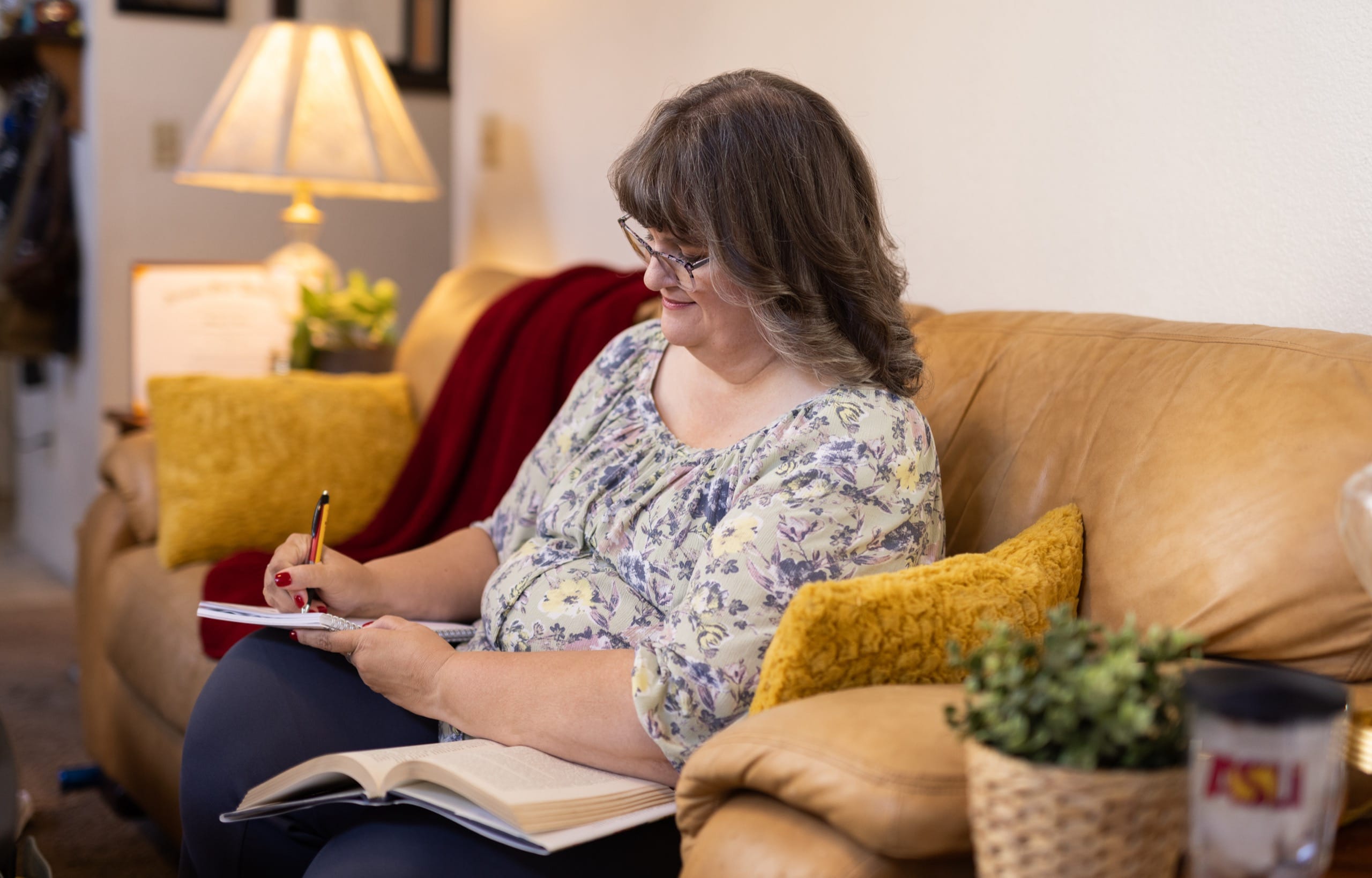 Woman sitting on couch and writing