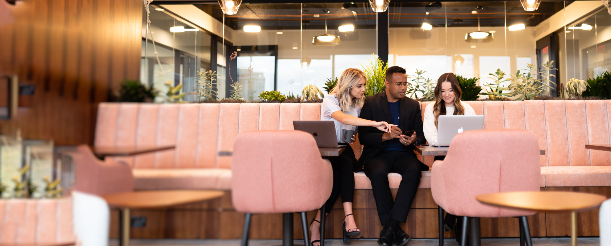 Three people looking at laptop