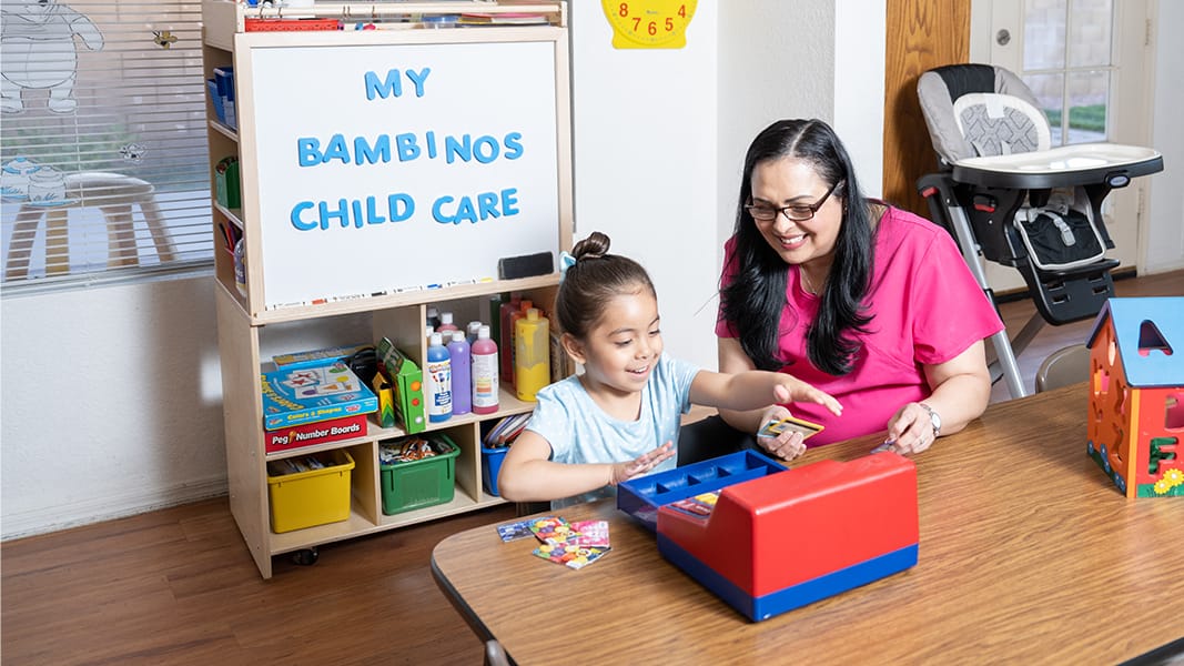 Teacher and child playing at table