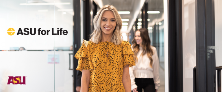 A blonde woman in a yellow leopard-print dress smiles while walking through a modern office hallway, with the "ASU for Life" and "ASU" logos displayed on the left.