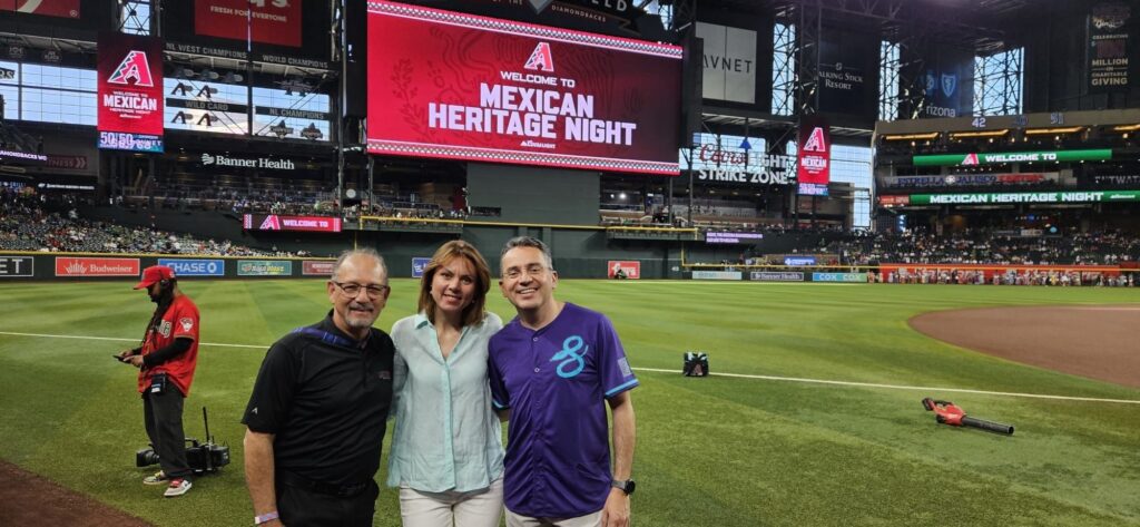 From left, Los D-backs Hispanic Council honorary chair Emilio Gaynor, Yuliya Hrushyk, and her husband, ASU Learning Enterprise Vice President Marco Serrato, on the field at Chase Field during Mexican Heritage Night. Gaynor nominated Serrato for the pregame recognition celebrating community leaders who expand opportunity across Arizona.