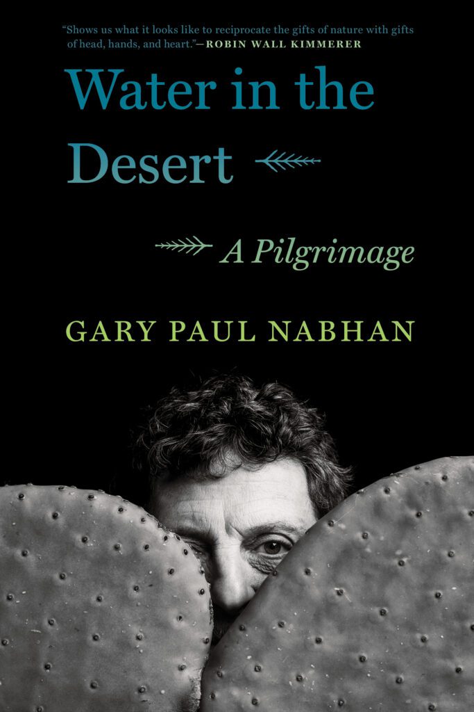 Water in the Desert cover with Gary Paul Nabhan between two cactus pads.